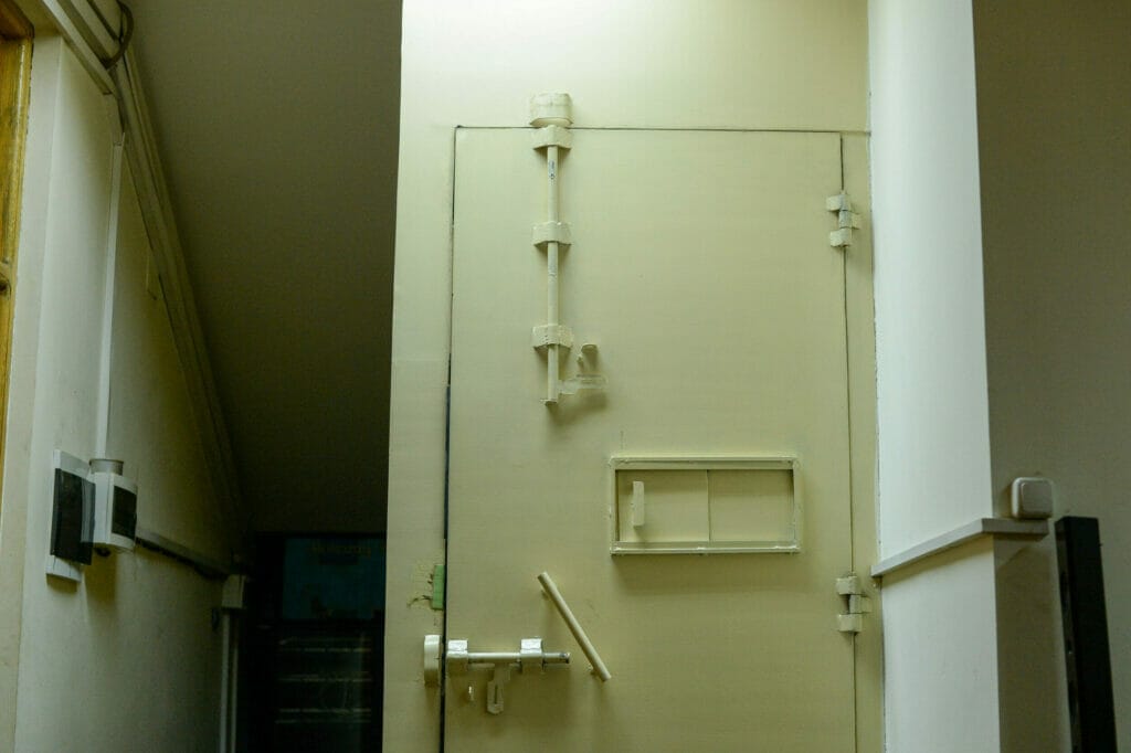 Stahltür mit großen Riegeln und Fenster zum Aufschieben.