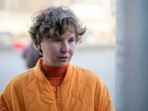 Nina Mamontova steht und trägt eine orangefarbene Jacke.