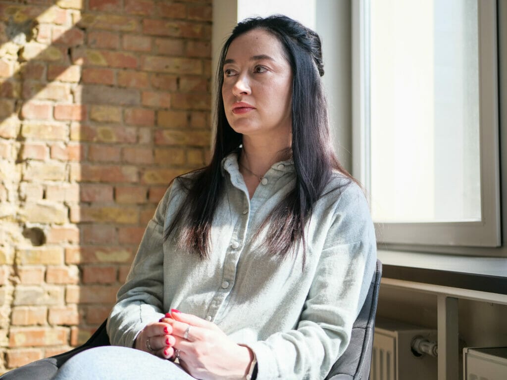 Mariia Stetsyuk sitzt in einem Stuhl. Sie leitet die Gruppenangebote für Angehörige des Veteran Hub in Kyjiw.