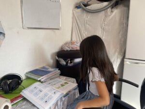 A girl sitting in a chair reading a book.