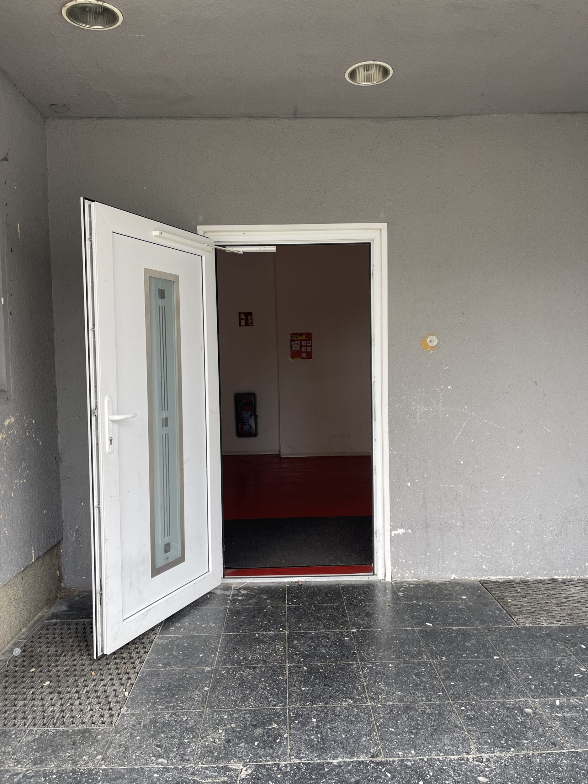 A white door with a red door in front of it.