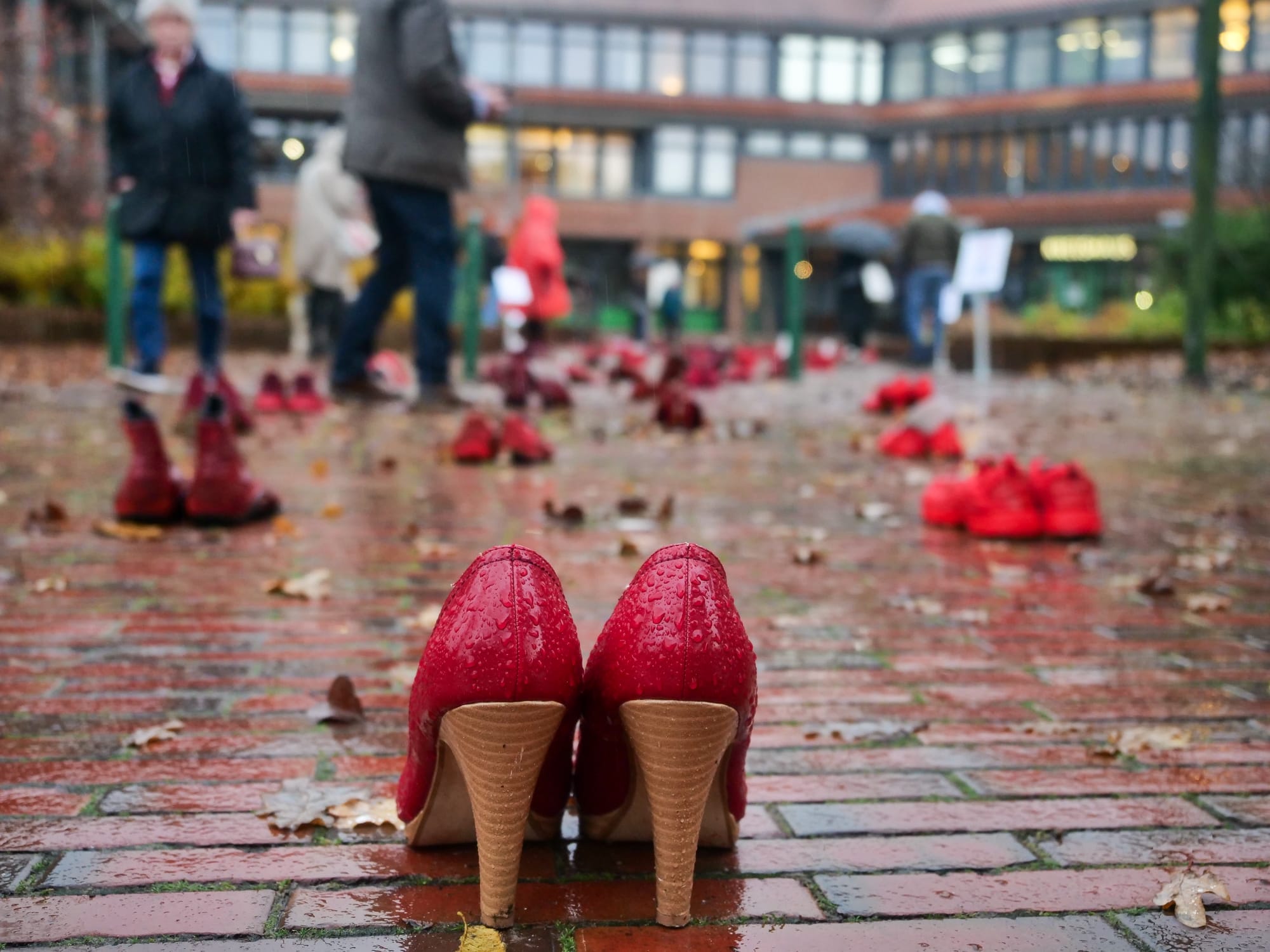 Eine Gruppe roter Schuhe auf einem gemauerten Gehweg.