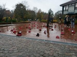 Eine Gruppe von Menschen läuft mit roten Schuhen auf dem Boden durch einen Park.