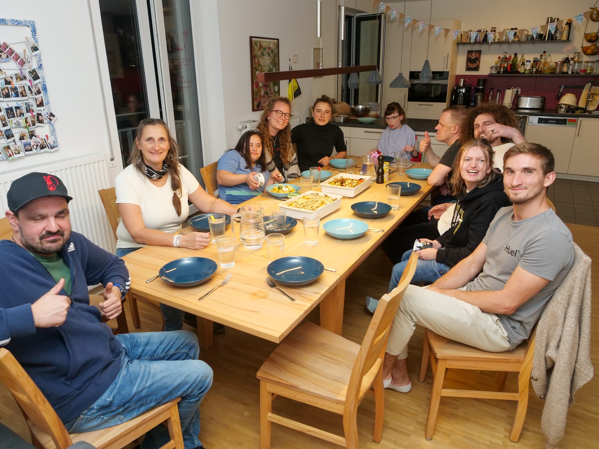 Die Münchner Inklusions-WG versammelt sich an einem Tisch.