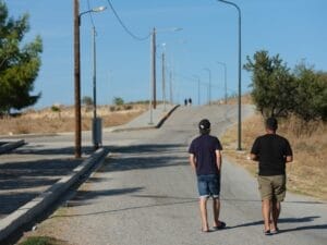 Zwei Männer gehen eine Straße entlang.