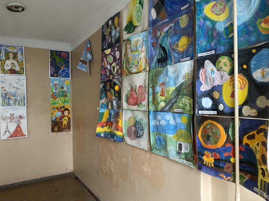 Ein Raum voller Gemälde an der Wand.