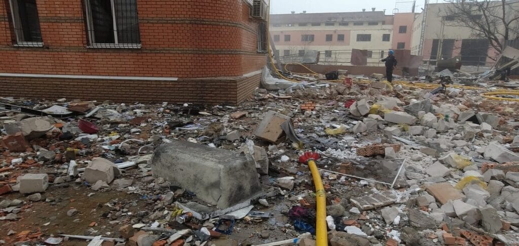 Debris and damage outside a building following a destructive event.