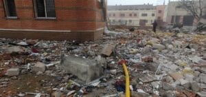 Debris and damage outside a building following a destructive event.