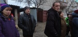 Eine Gruppe besorgter Erwachsener steht draußen, in einem Wohngebiet in Lyman.